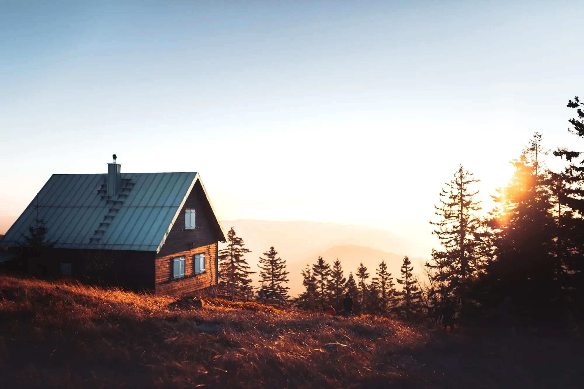 Cabin on a hillside at sunset