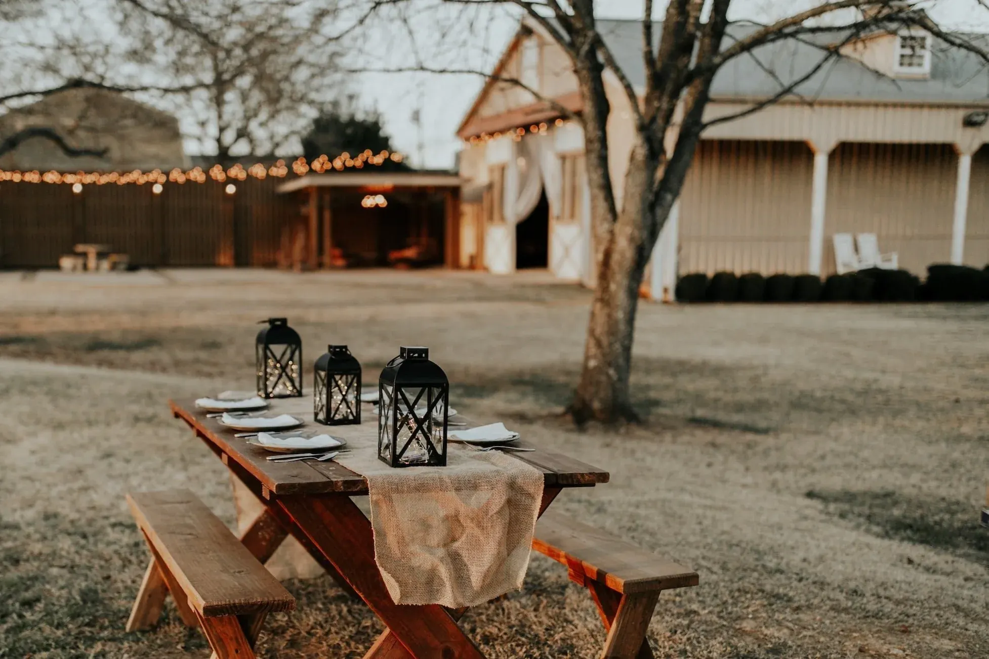Outdoor dinner table with lanterns and string lights