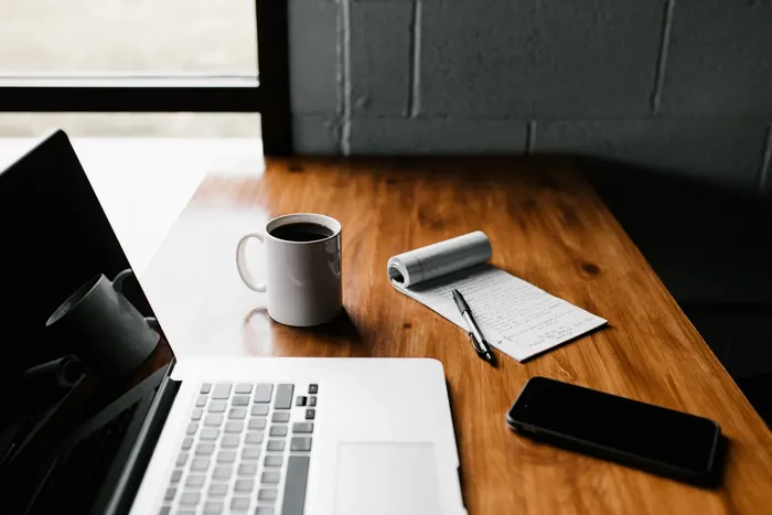 Laptop, notebook and coffee on a desk